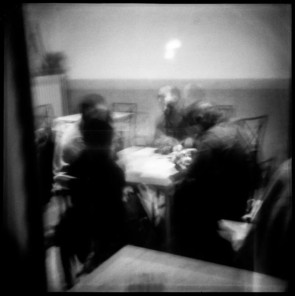 Four men playing cards in a bar, in Italy. Shot through the window.