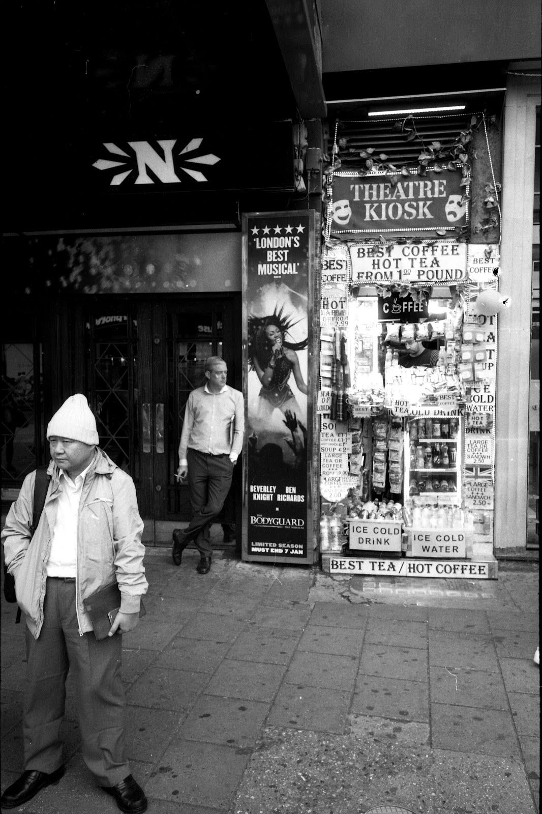 Two men waiting outside a theatre near Tottenham Court Road, London