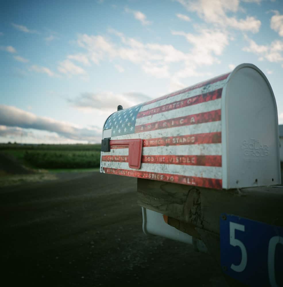 A close-up of a mailbox outside the little town of Tieton, WA, with apple orchards in the background.