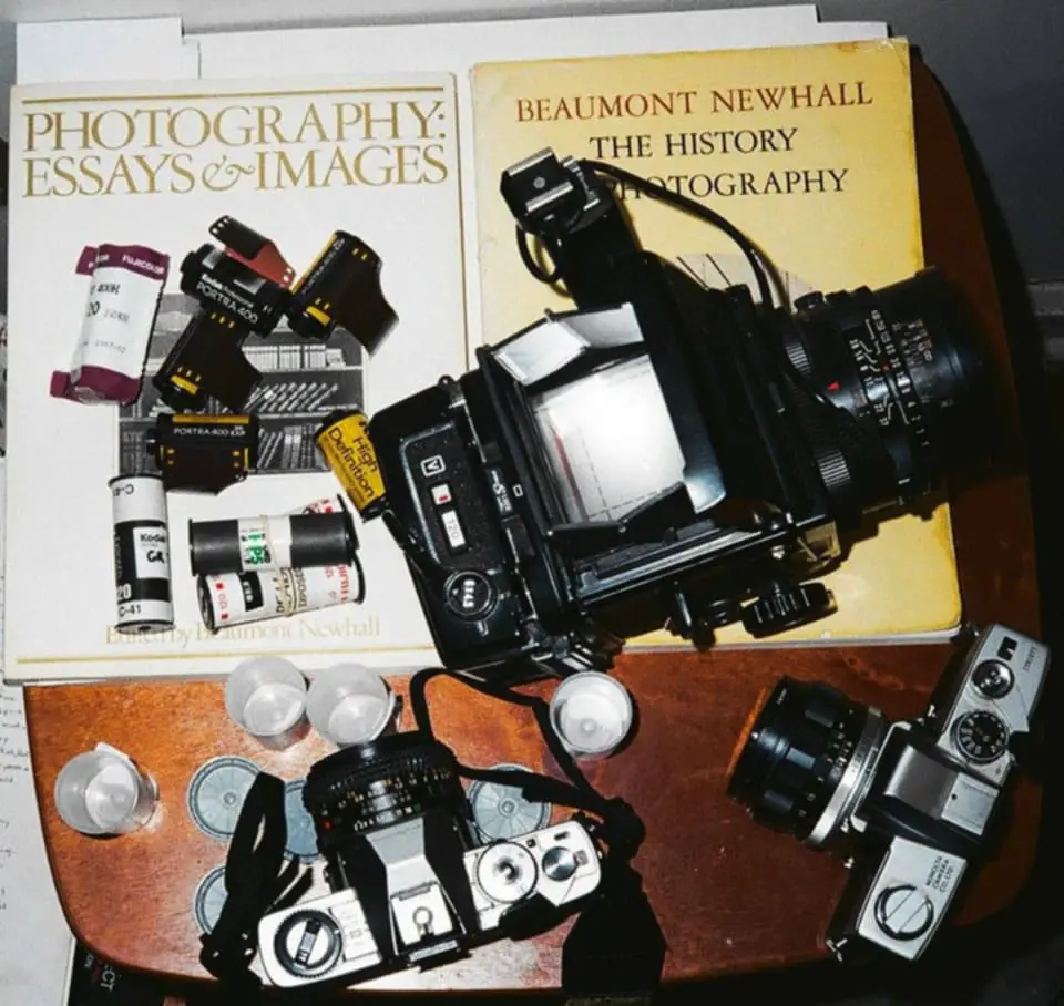 Photographed on medium-format film (Kodak Portra 400). A Braun camera flash was used for this frame. The organization of the instruments (cameras) and the rolls of film are a mirror in a symbolic way, because film was used to photograph film. Also, the literary works serving as the backdrop are a pre-meditated sign of showing how important the articulation and dialogue of photography has to be a part of the future, if this medium want to be culturally preserved.