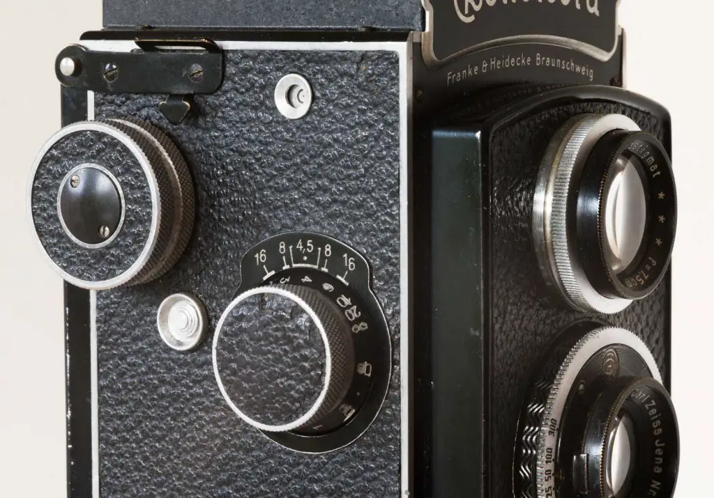 Rolleicord side view showing film winding knob, frame number window, reset button and focusing knob with DOF markings