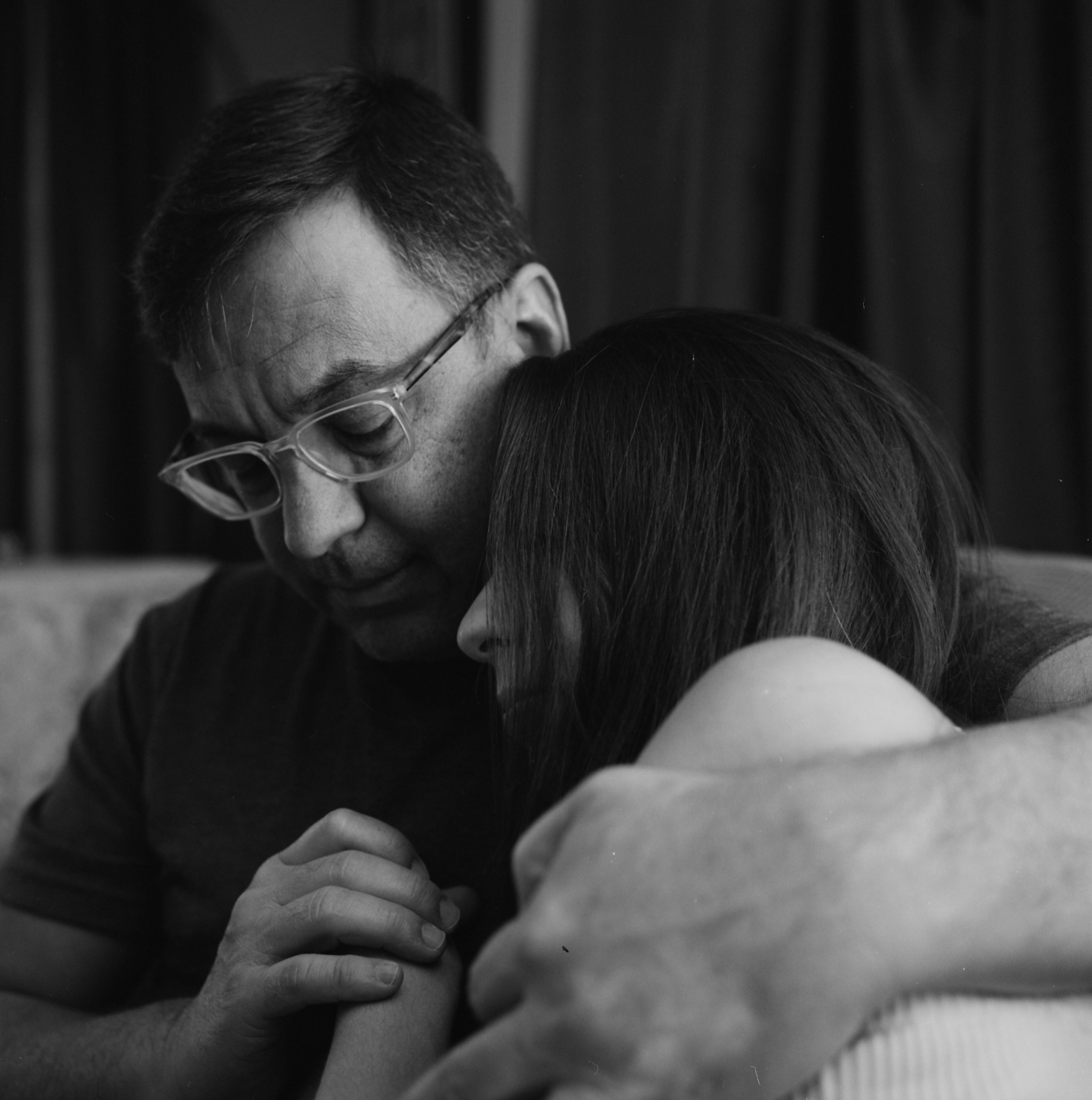 a man and a woman hug on a sofa