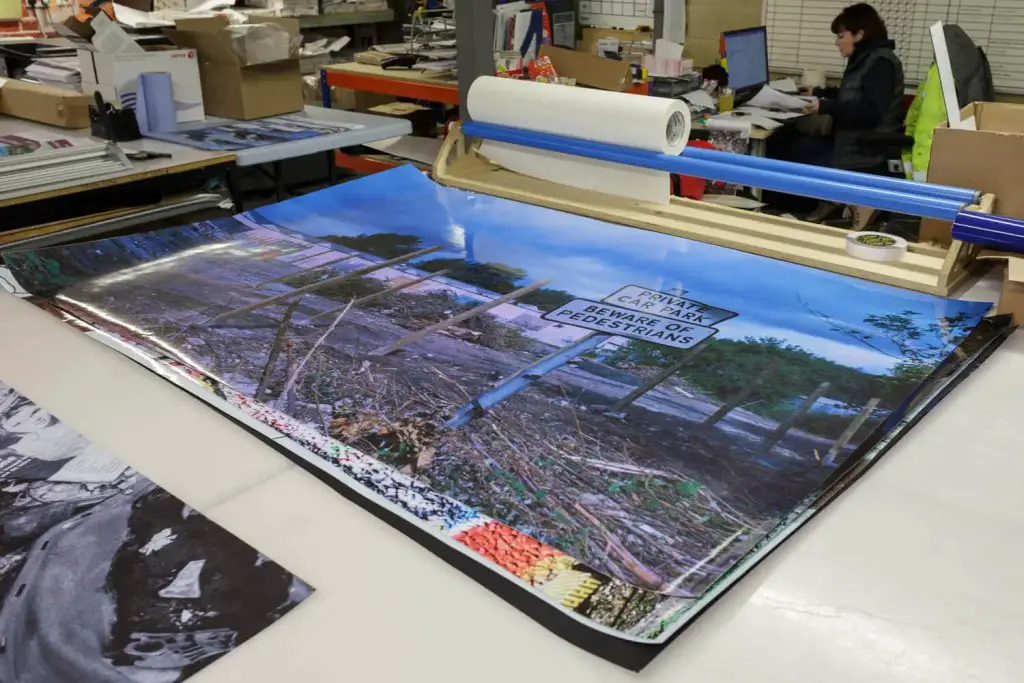 A 1.5 by 1 metre colour print is laid out on a printer's bench.