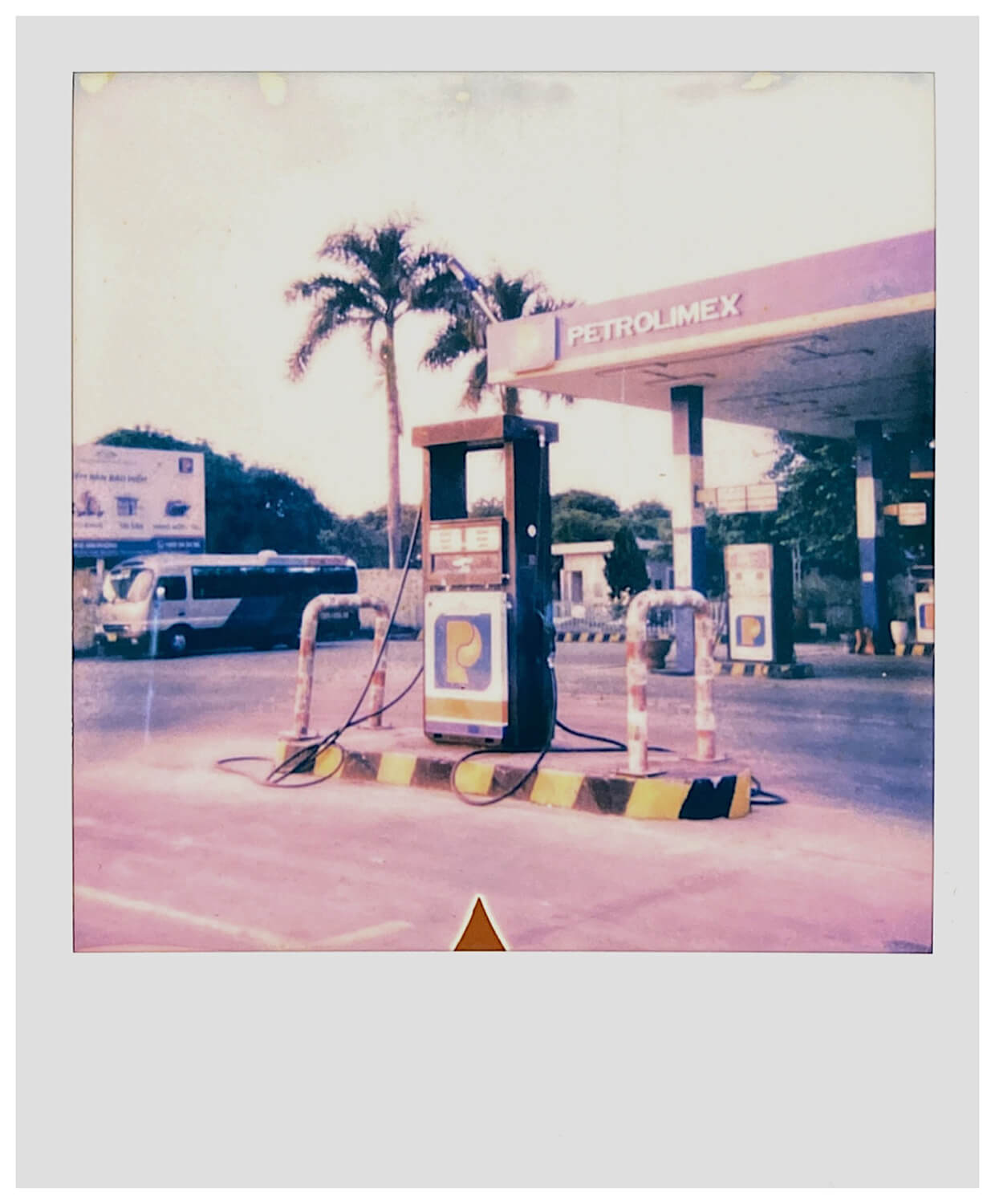 A Polaroid photo of a gas station during a sunny day, a bit overexposed and it was shot using a Polaroid 636 Talking camera.