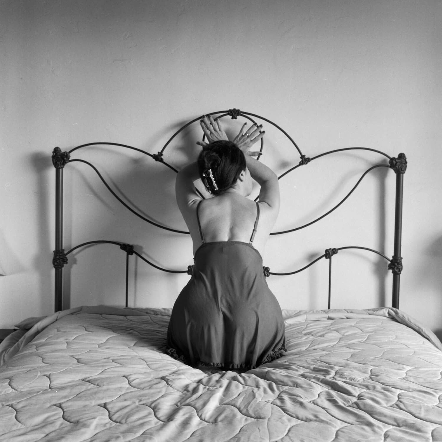 Model on antique bed - Here is a case where the photograph is all about symmetry. The subject is posed in dead center of the image. Shot with a Rollei 3.5f and Kodak T-MAX 400 film